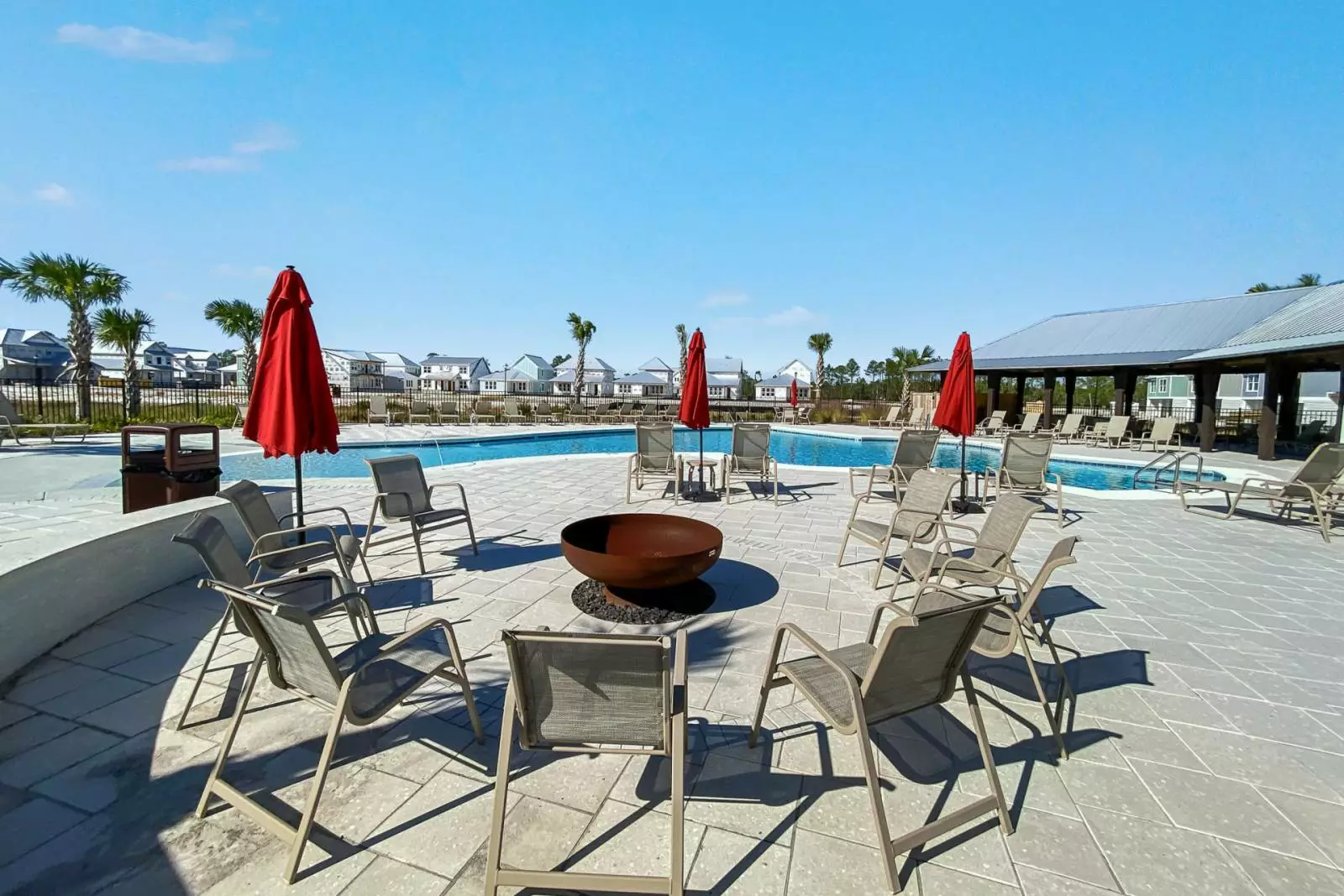chairs and fire pit next to pool
