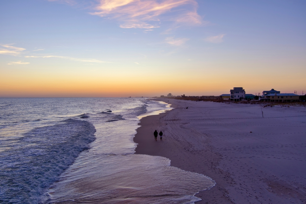 couple walking on Alabama beach in fall