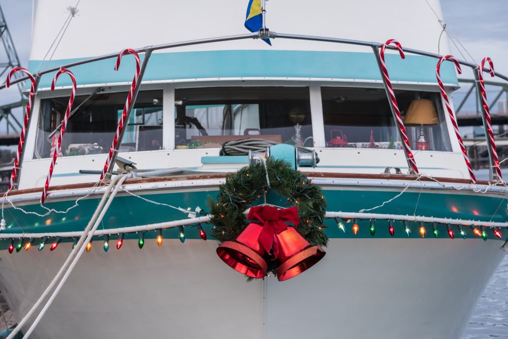 boat docked at marina decorated with Christmas lights and wreath