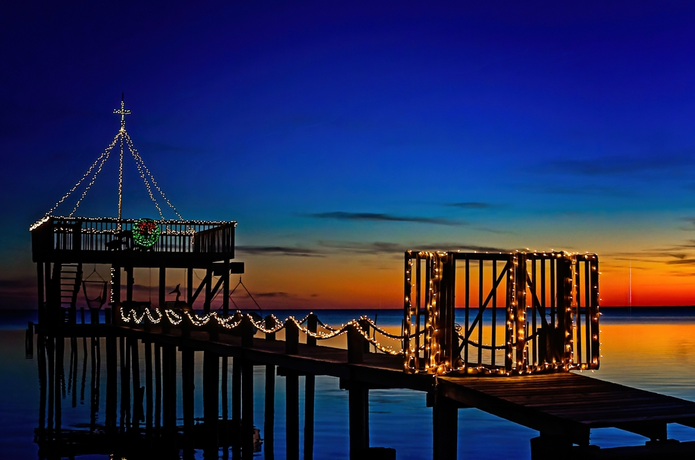 Christmas lights on boat dock at sunset