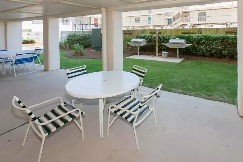Community charcoal grill area at Casa Del Sol condominiums with table seating available for guest use.