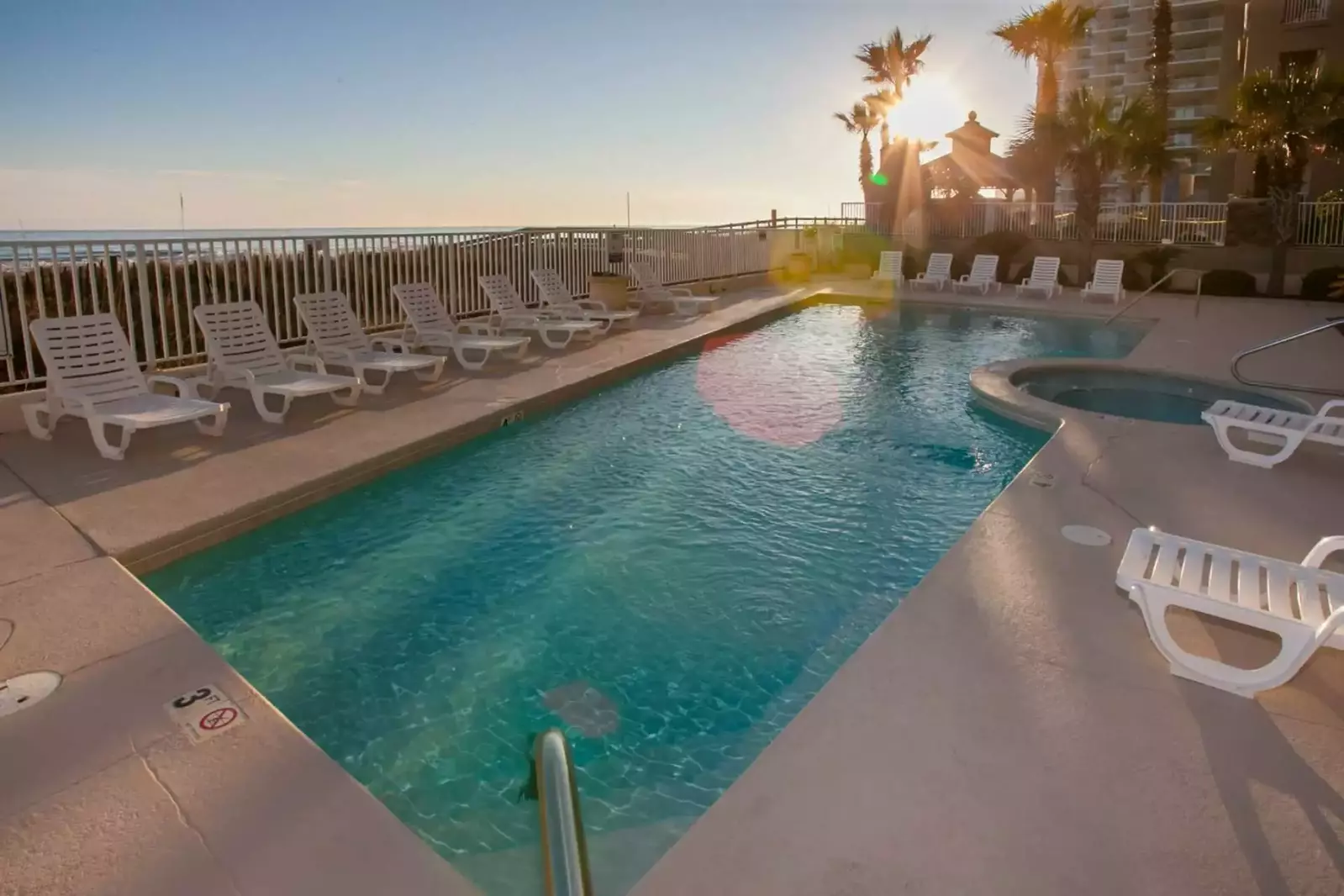 Community pool and hot tub with surrounding lounge chairs