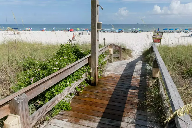 Boardwalk with outdoor shower leading to beach and Gulf