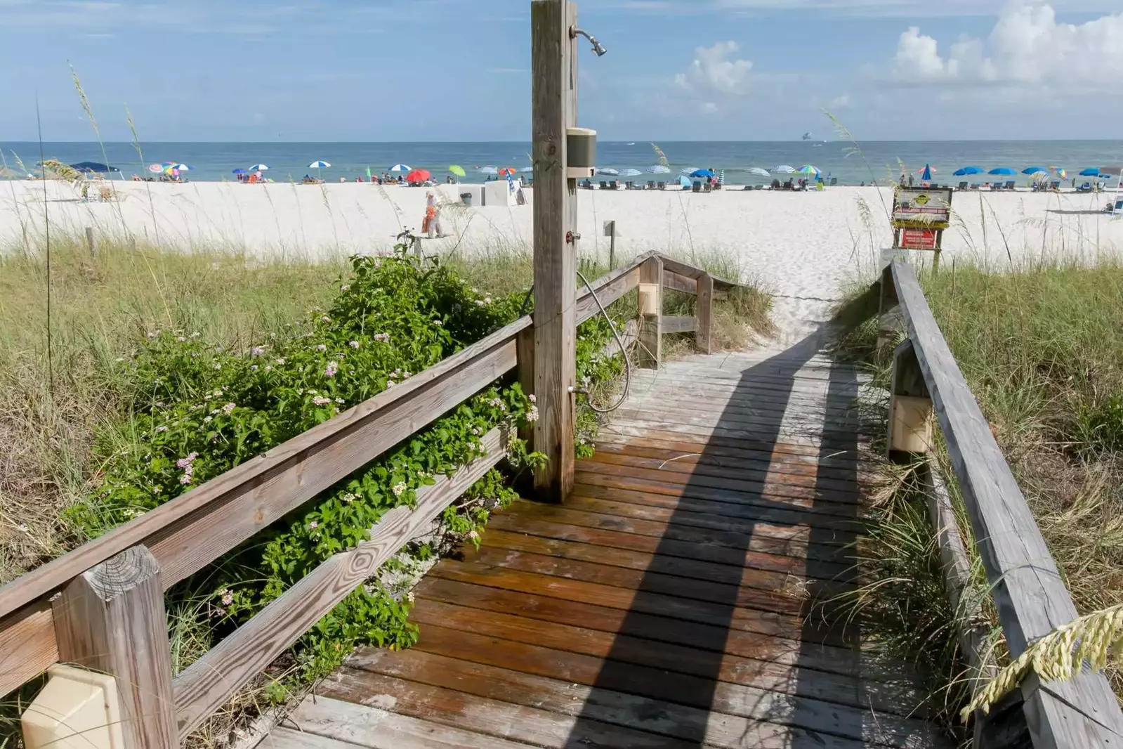 Boardwalk with outdoor shower leading to beach and Gulf