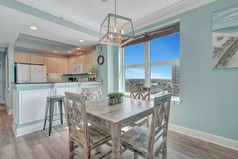 Dining area with seating for four at the table and two stools at the breakfast bar. Large window provides a lovely backdrop to any meal!