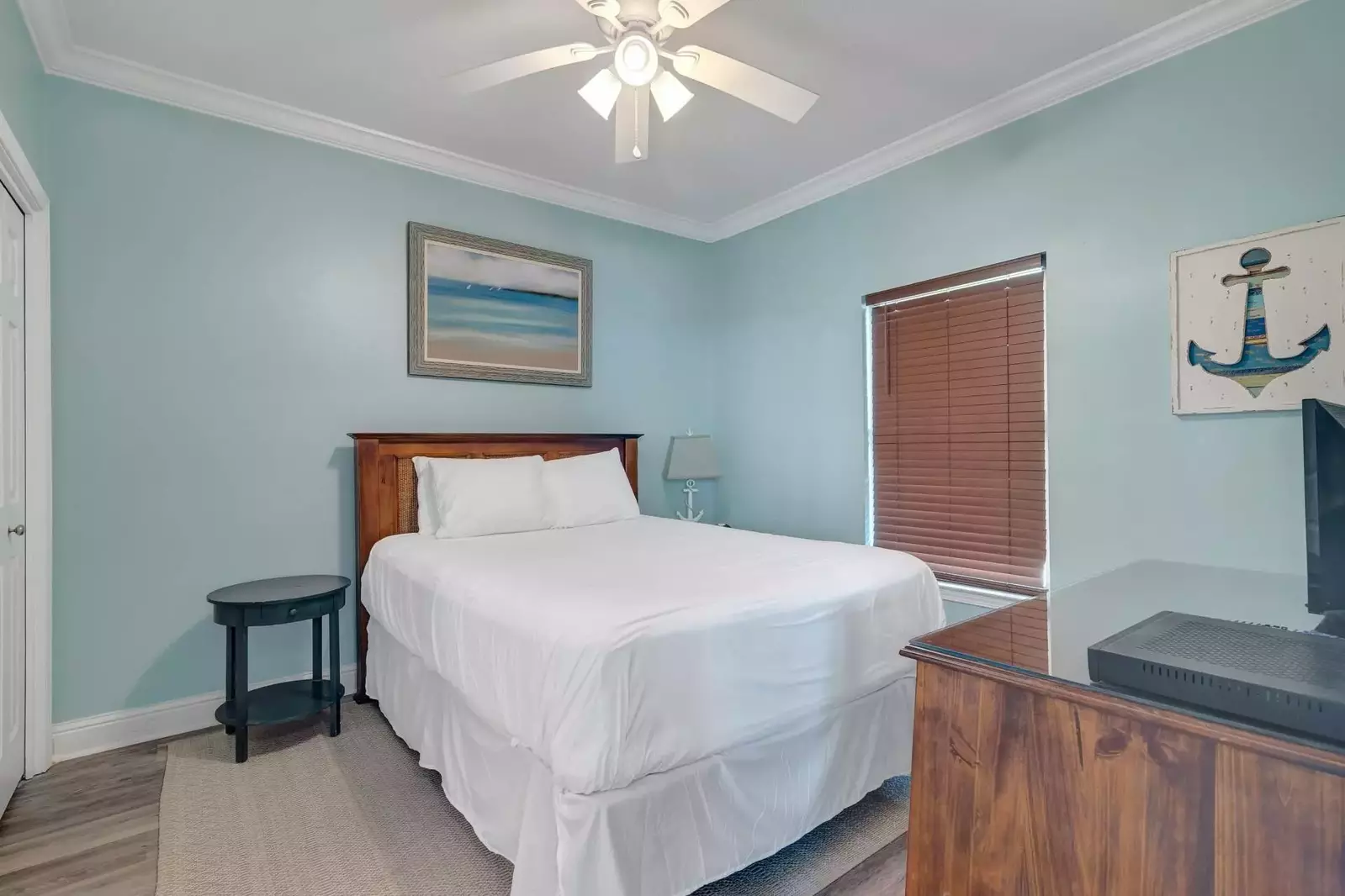 Guest bedroom with a queen bed and TV.