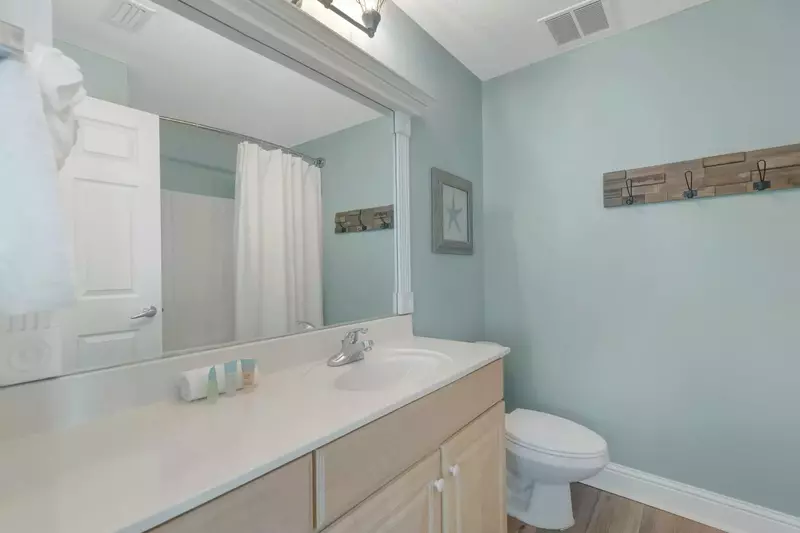 Primary bath with large mirror and tub/shower.