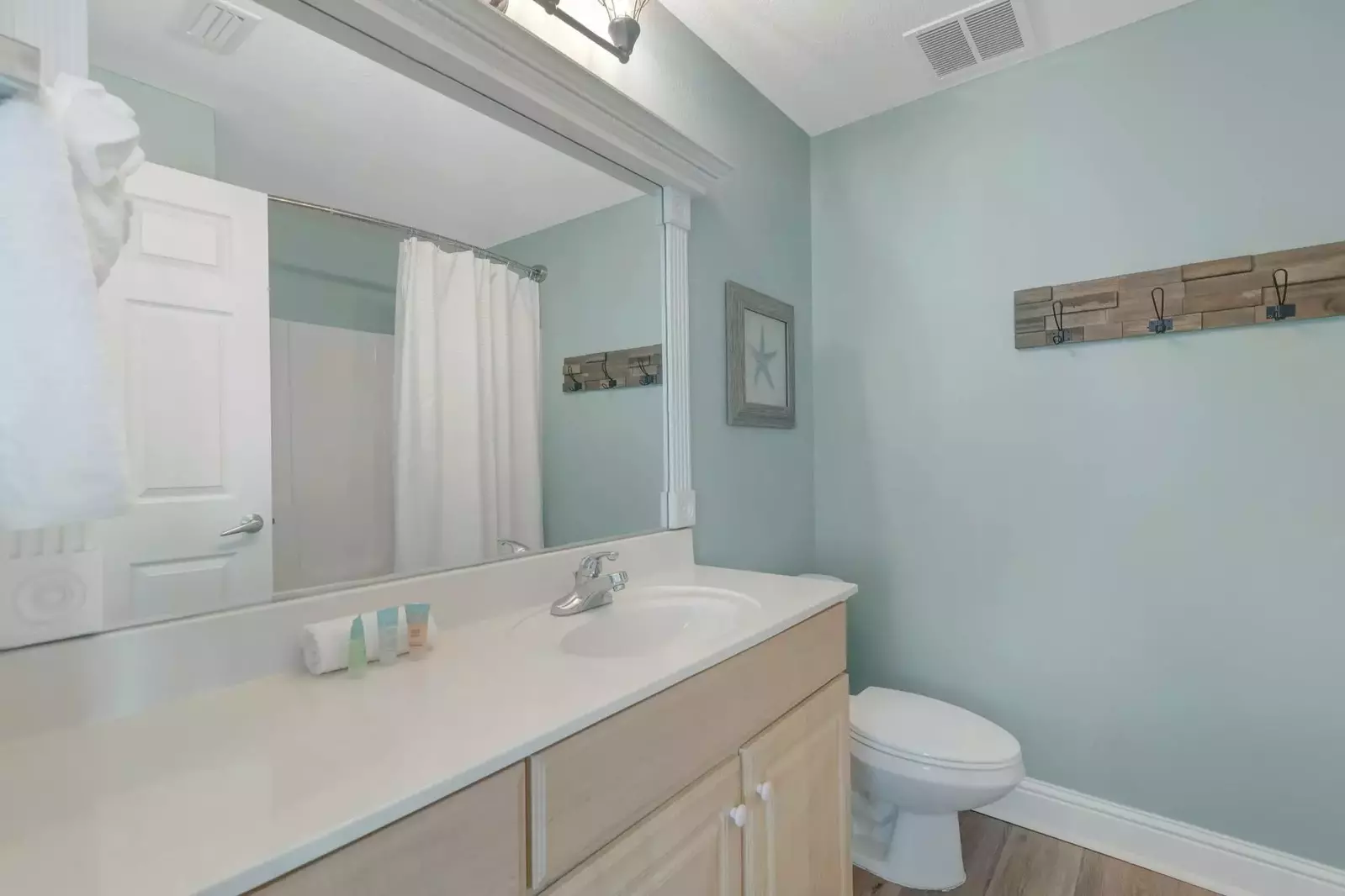 Primary bath with large mirror and tub/shower.