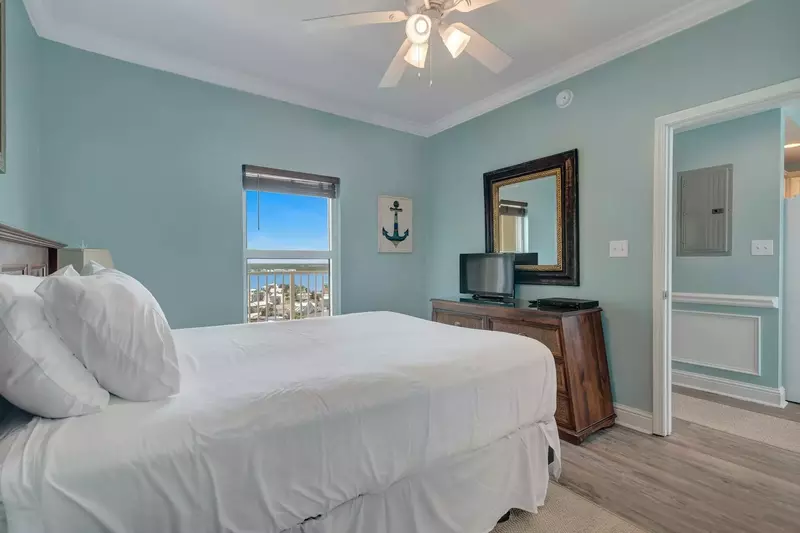 Guest bedroom with queen bed, TV with a DVD player, and a dresser.
