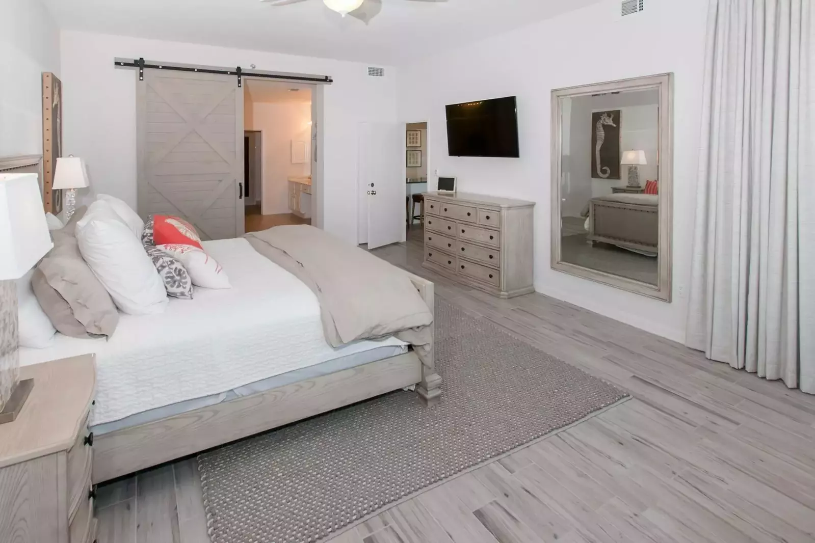 Large primary bedroom with dresser and flat screen TV