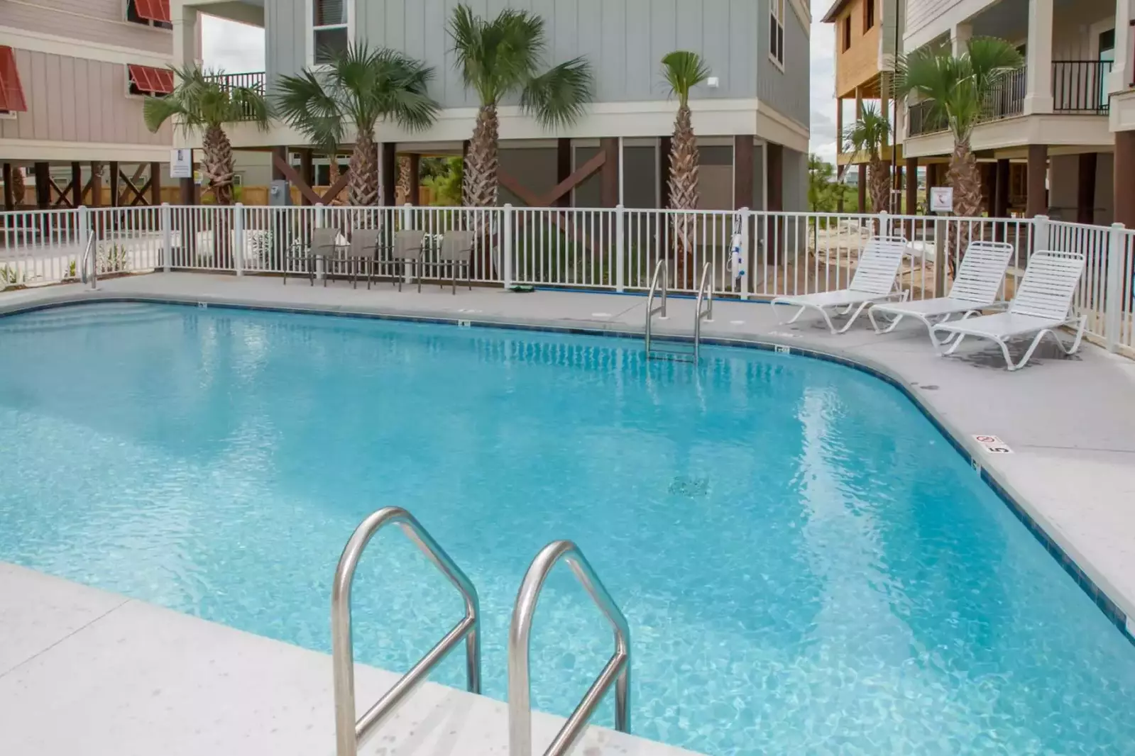 Community pool w/lounge chairs and alfresco dining