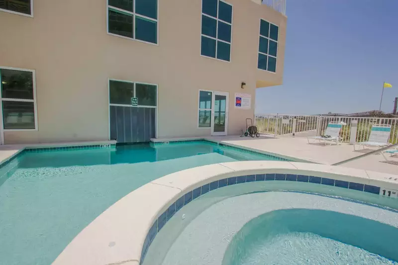 Pool and hot tub overlooking boardwalk to beach.