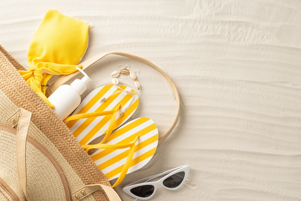 beach bag with sunglasses, flip flops, sunscreen, swimsuit